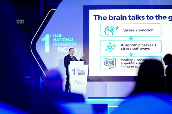 Dr Pranab Gyawali at the lectern explaining brain-to-gut communication